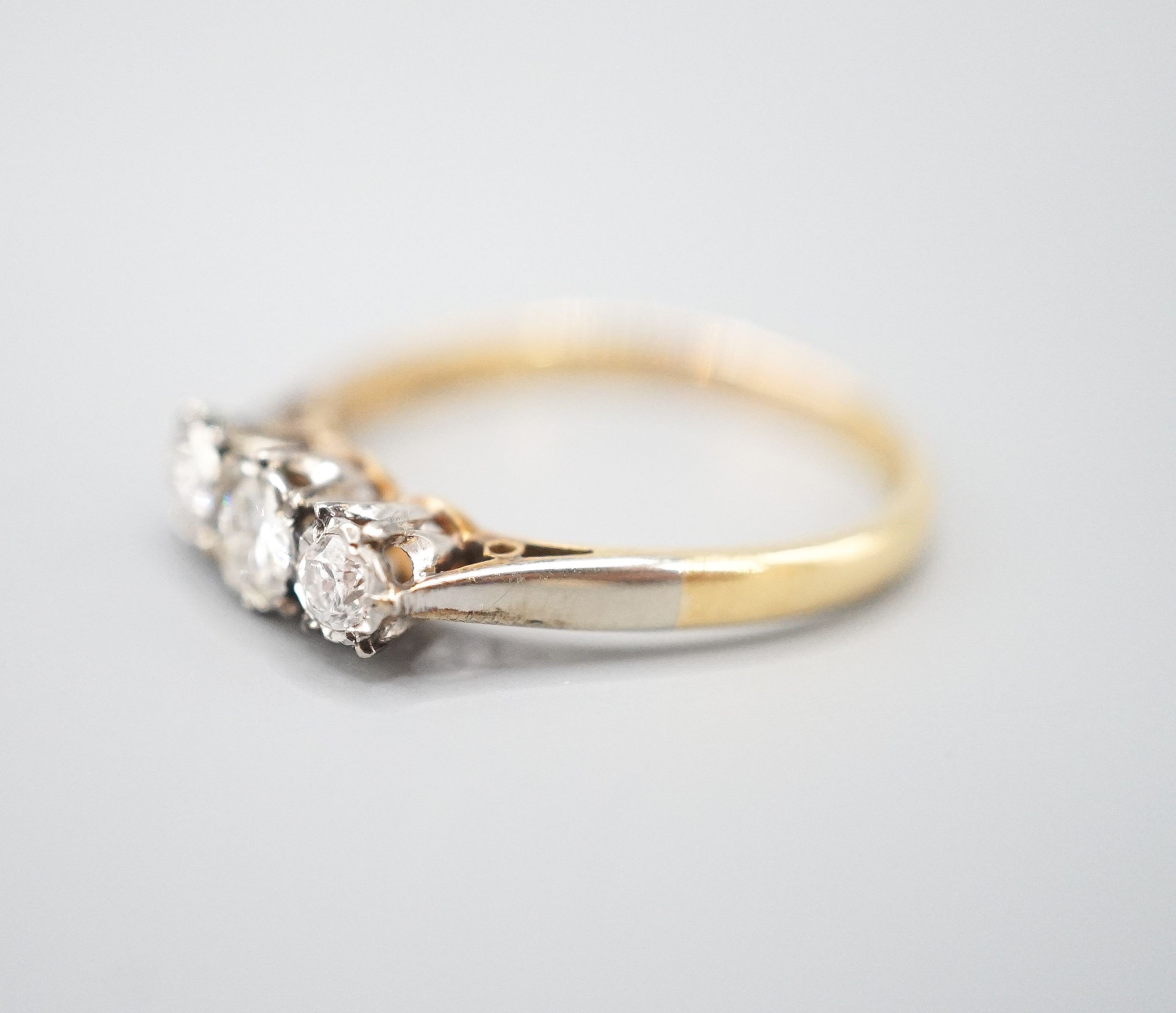 A modern 18ct gold and three stone diamond ring, size Q/R, gross weight 3 grams.